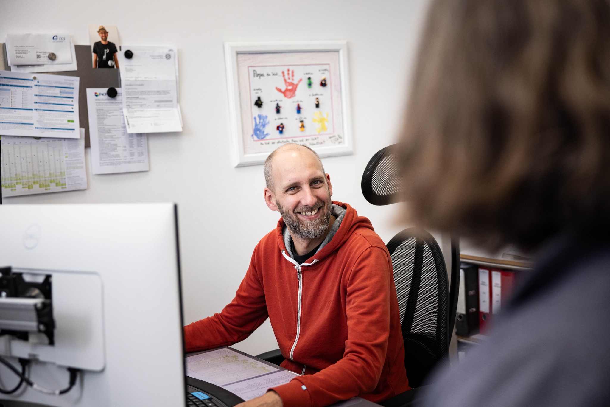 Mitarbeiter am Arbeitsplatz und spricht mit einer Person
